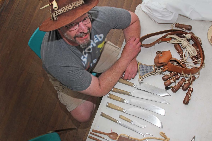 Man surrounded by sharp medieval knives.