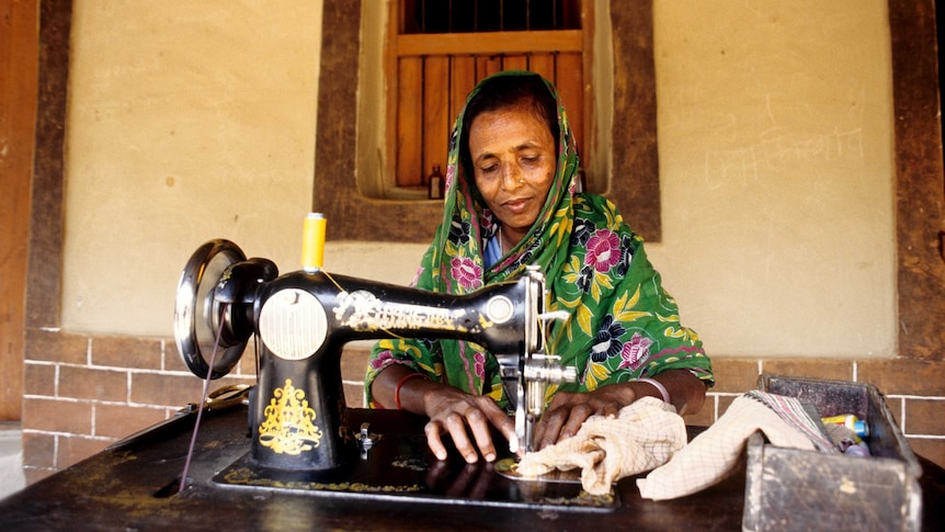 Middle aged woman in Bangladesh operating sewing machine.