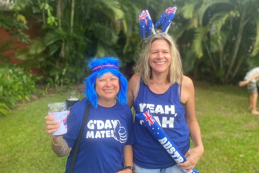 A woman in a blue wig and a woman with blonde hair wearing Australia Day merch.