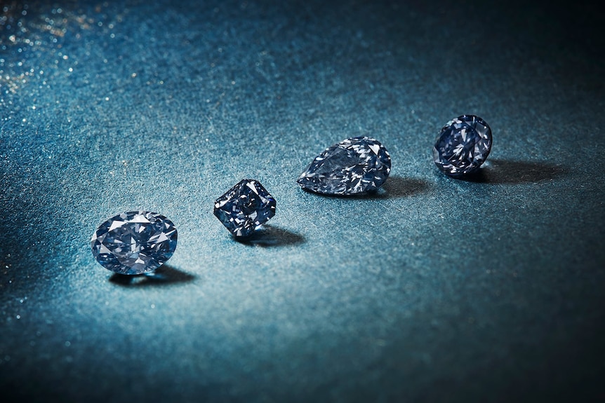 Four blue diamonds against blue background