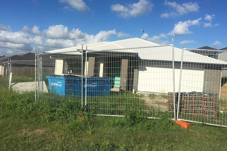 Unfinished home being built at River Run Circuit at Ormeau Hills with security fencing