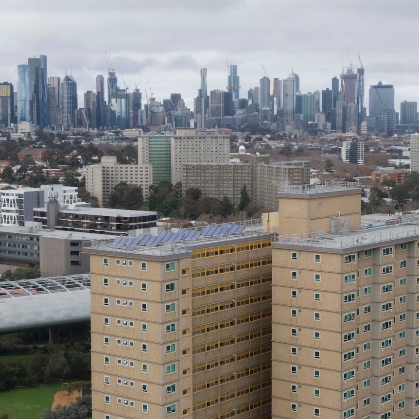 two public housing towers can be seen with the Melbourne city skyline in the background