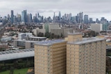Two public housing towers can be seen with the Melbourne city skyline in the background.