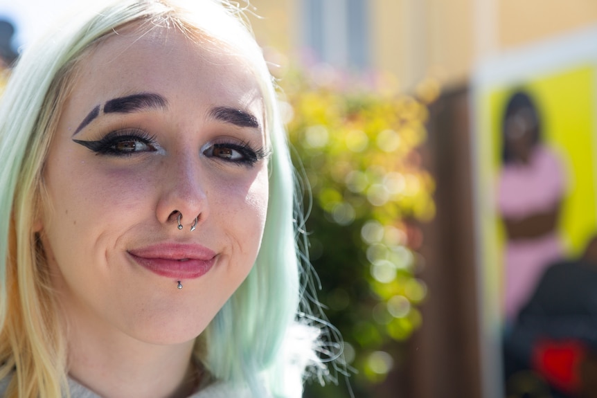 Bridie Fahey smiles for a portrait photograph under sunlight in the school playground.