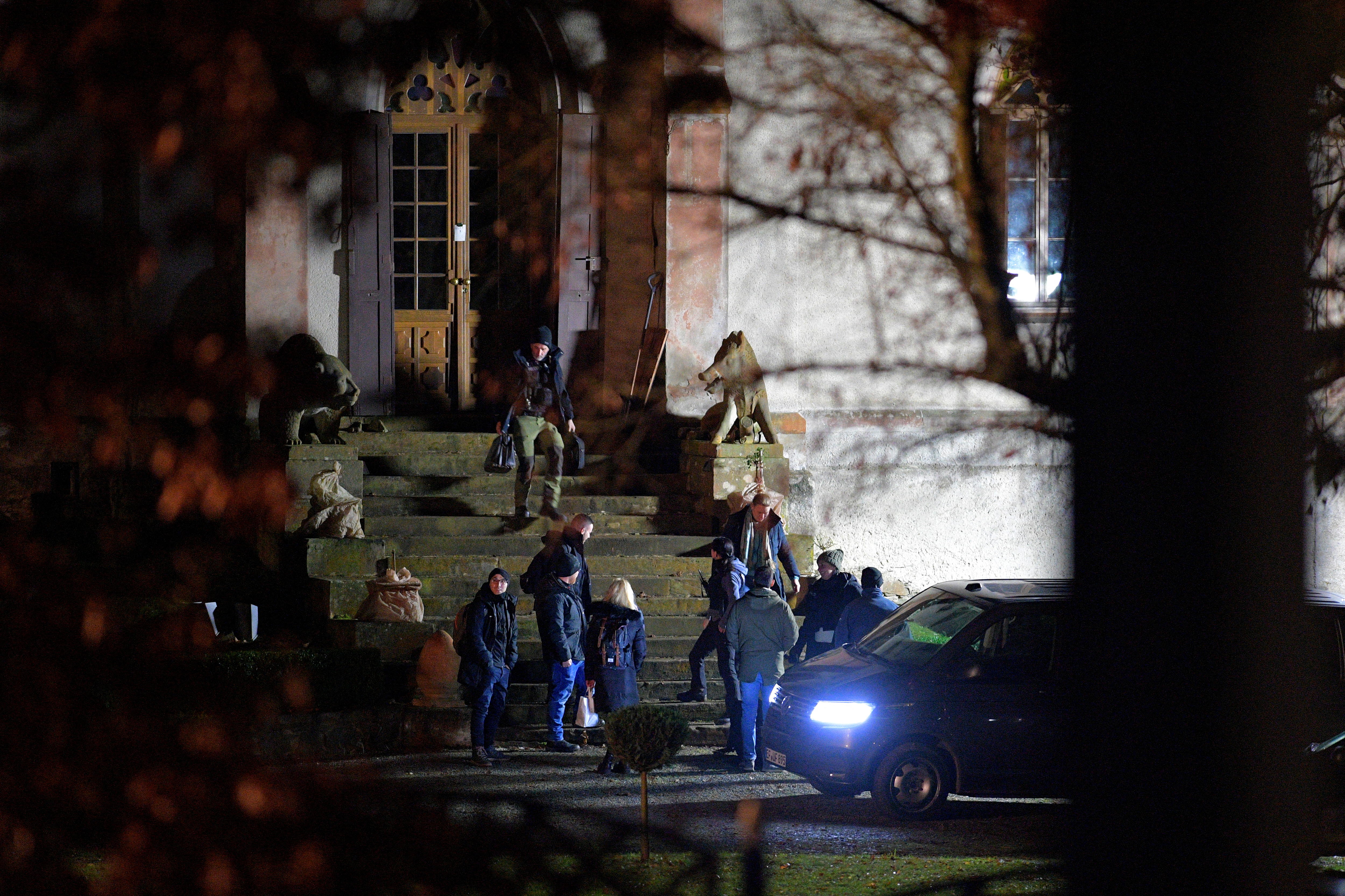 Police walking up the steps of a hunting lodge.