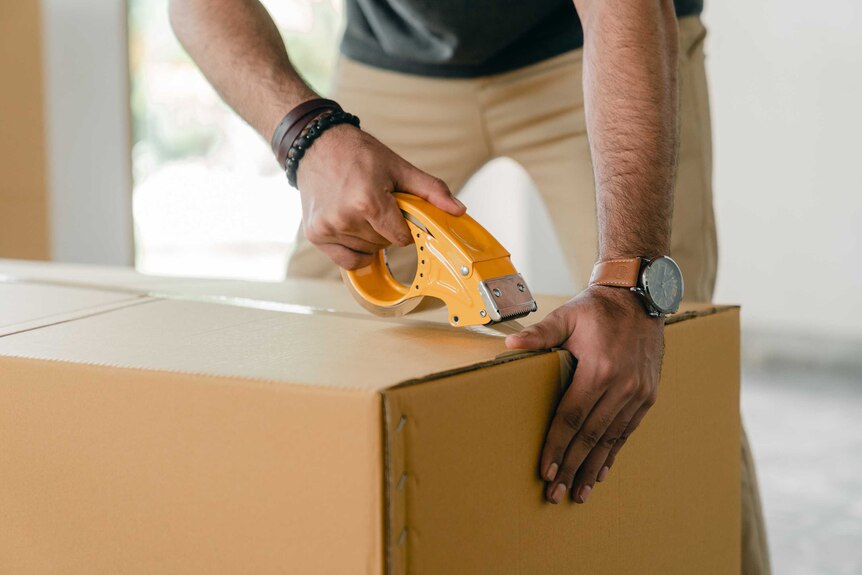 A man packs a cardboard box