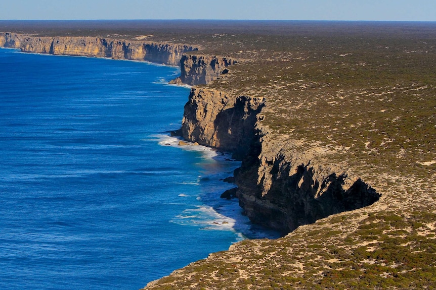 An aerial shot of cliffs next to the ocean.
