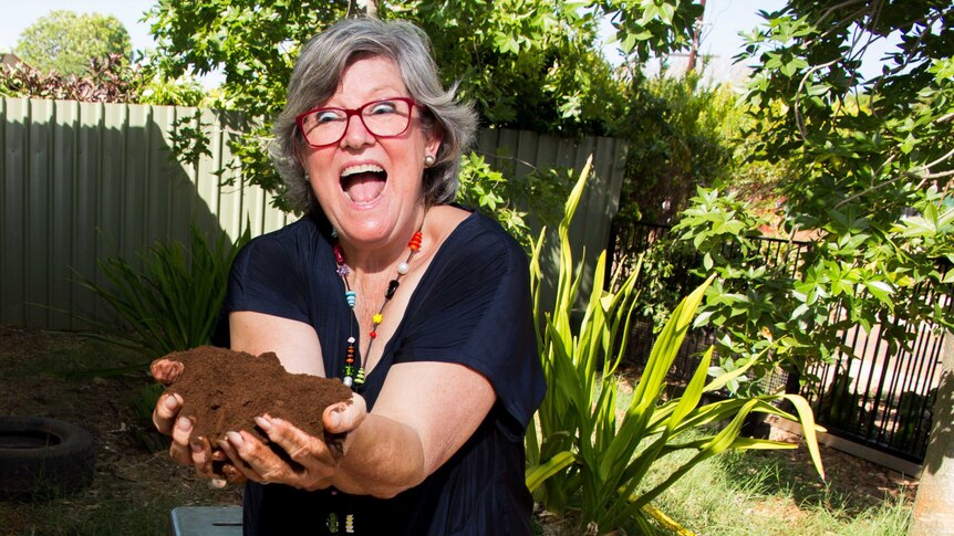Trish Pepper with her hands full of coffee grounds.