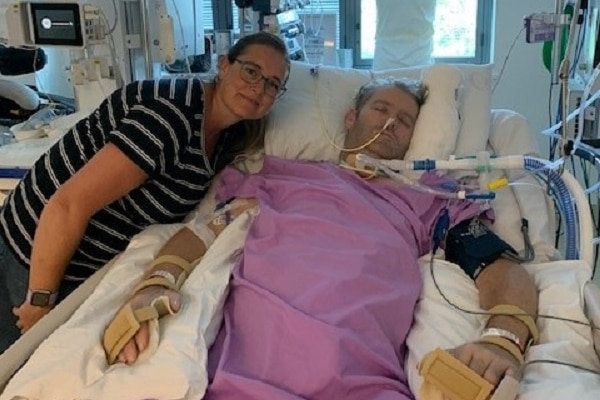 Unconscious Christian McDonald ill in Cairns Hospital intensive care unit with his wife Tamara beside his bed