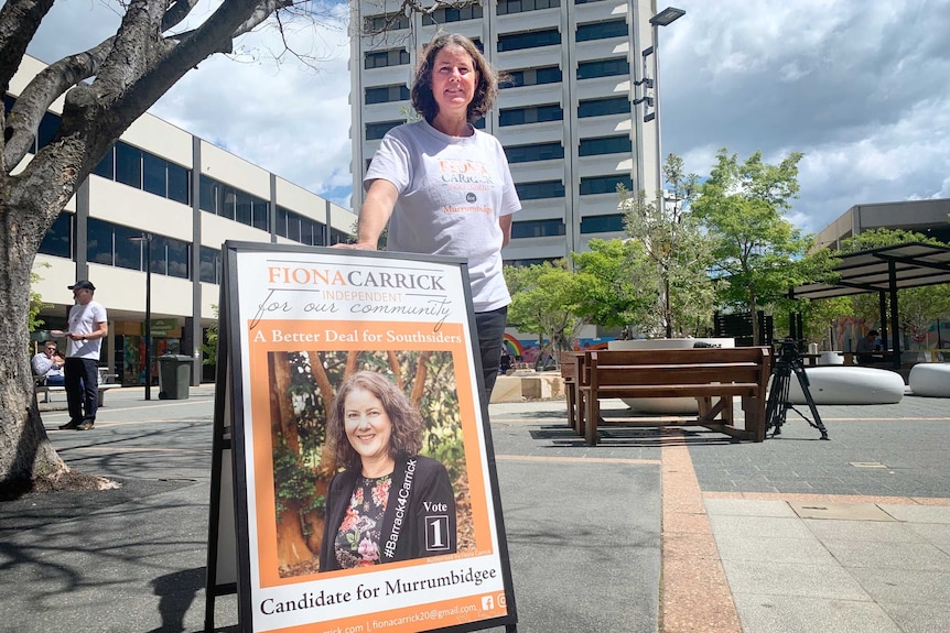 A woman stands next to a sign reading 'Fiona Carrick independent'.
