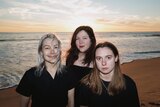 Phoebe Bridgers, Lucy Dacus and Julien Baker stand on an empty beach wearing black