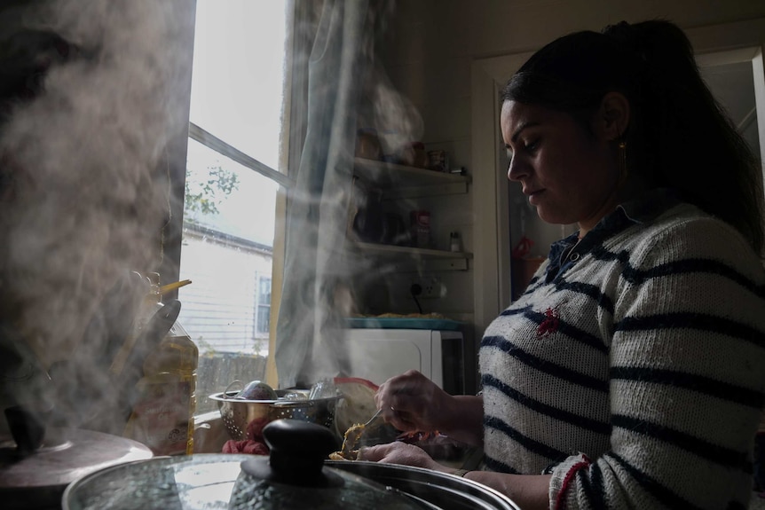 A woman cooking in a kitchen.