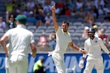Smiling Australian bowler Mitchell Starc points to the sky during a Test as Indian batsman Hanuma Vihari looks on.