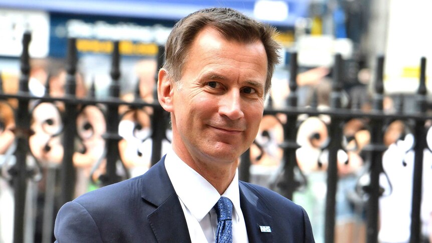 A head and shoulders image of Jeremy Hunt smiling while standing on a street.