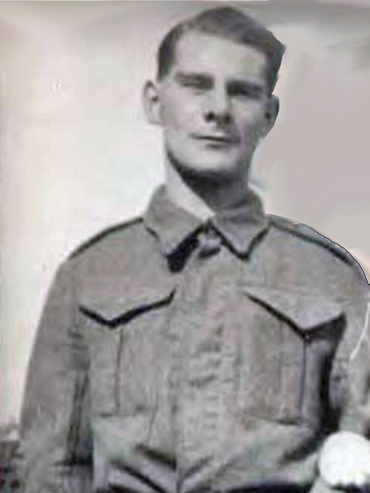 A black and white photo shows a young man standing.