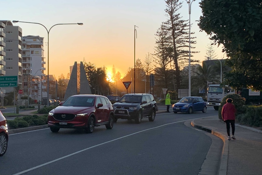 Cars in a line as the sun comes up.