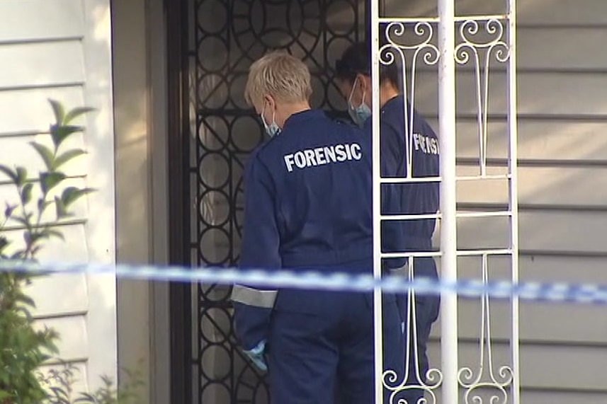 Two forensic offices go in the front door of  house in Mitcham, where a body was found.