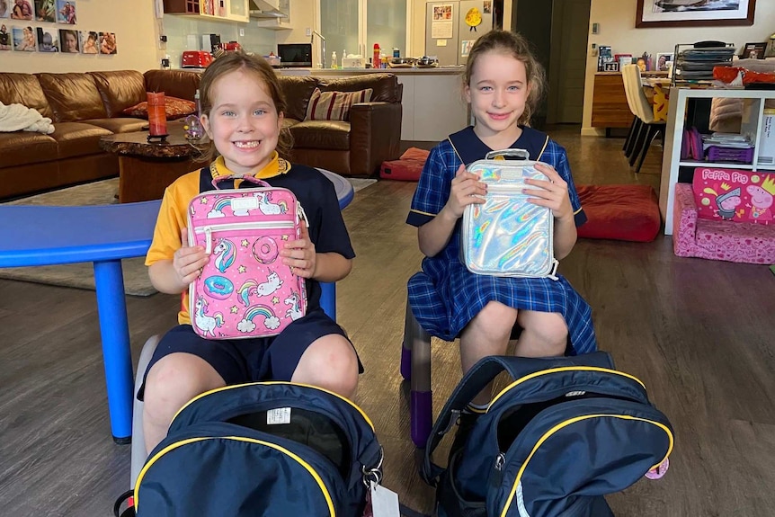 Maddeline and Charlotte Bailey hold up their lunchboxes.