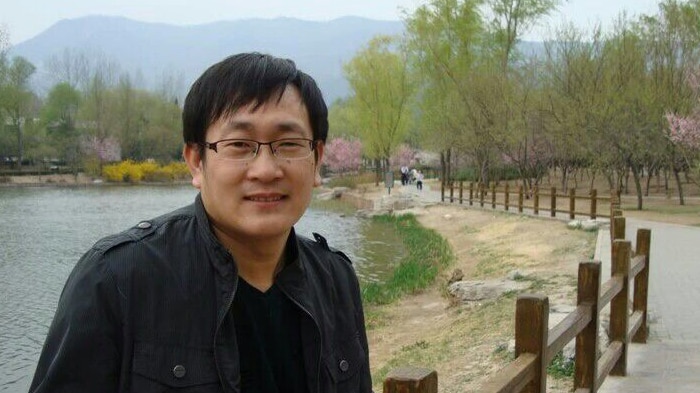 Wang Quanzhang stands in front of a lake