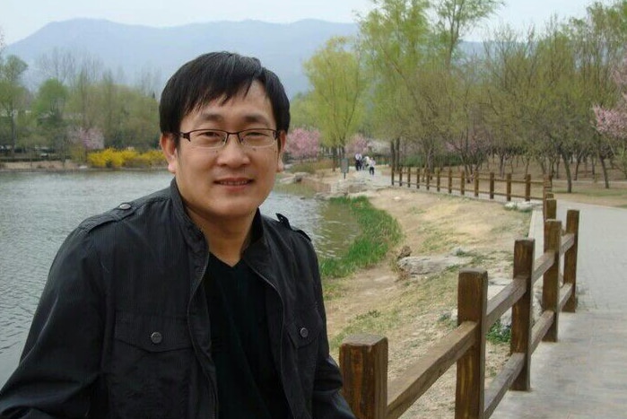 Wang Quanzhang stands in front of a lake