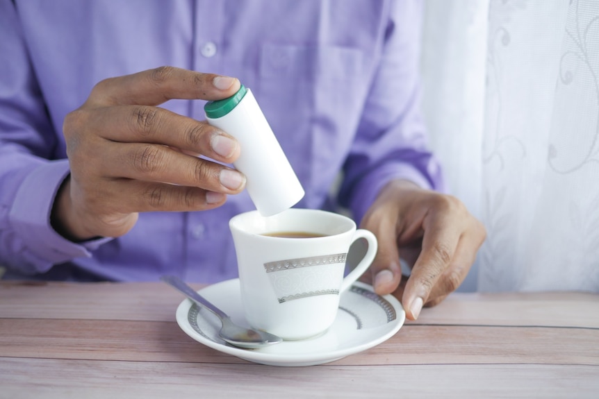 Sweetener being added to a cup of tea