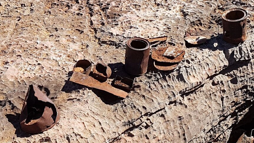 A photo of rusted tins, lids and other items.