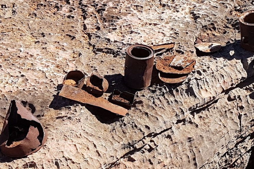 A photo of rusted tins, lids and other items.
