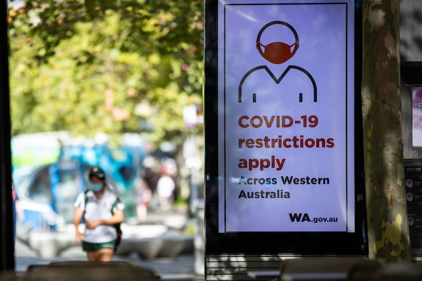 A large sign saying Covid-19 restrictions apply across Western Australia.