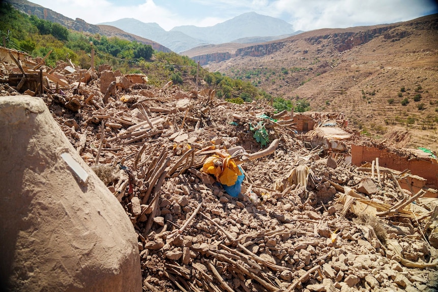 A large pile of rubble, with mountains visible in the background.