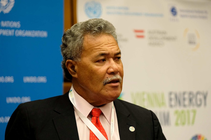 Enele Sopoaga, Prime Minister of Tuvalu stands in front of United Nations logos at an energy forum.