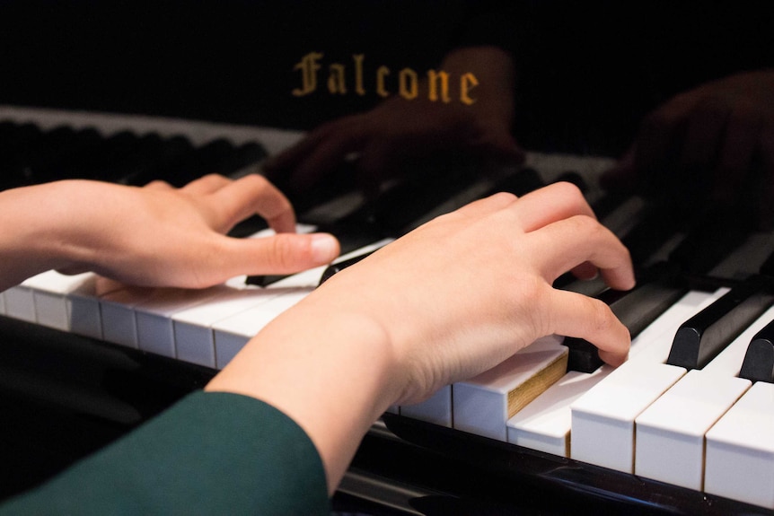 A close up photo of Irene Li's hands playing the piano