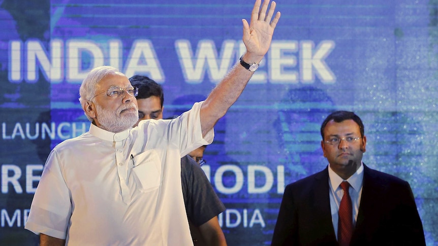 Narendra Modi waves as Cyrus Mistry (R), chairman of Tata Group watches during the launch of Digital India Week