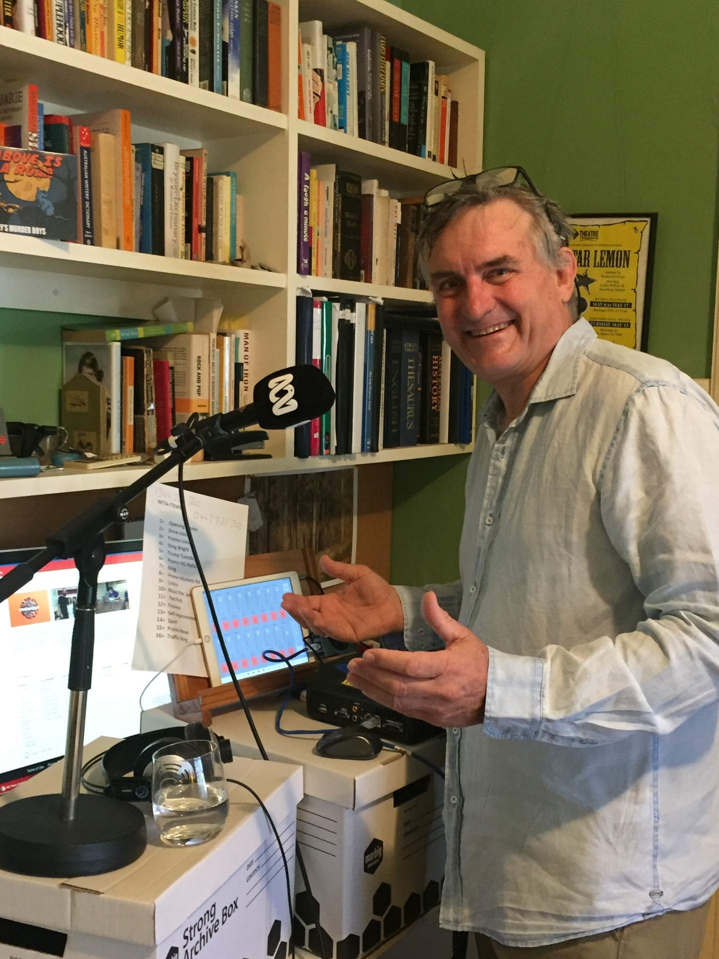 Glover standing at desk in front of ABC microphone.
