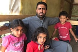 Refugee Ahmad with his three children at a refugee camp