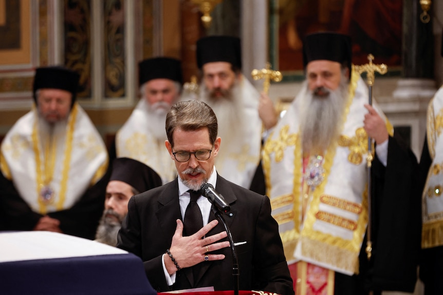 The former prince of Greece is pictured giving a eulogy at his father's funeral. 