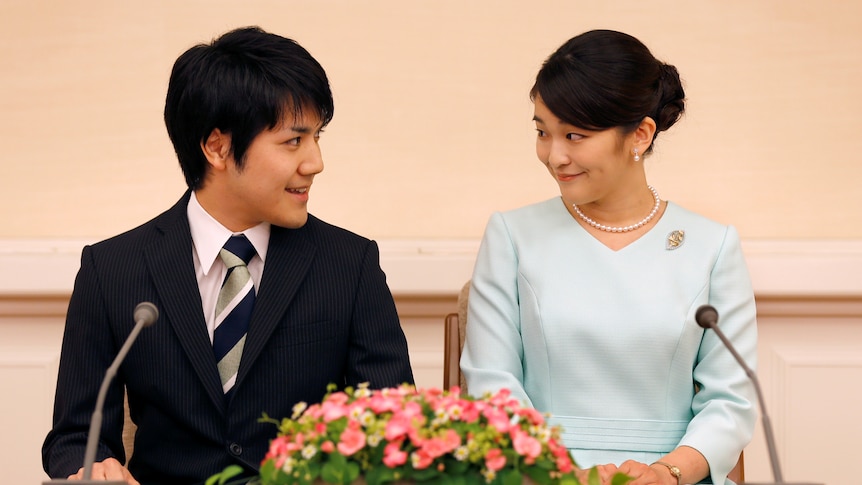 Princess Mako and Kei Komoru sit at a table and look lovingly into each other's eyes.