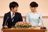 Princess Mako and Kei Komoru sit at a table and look lovingly into each other's eyes.