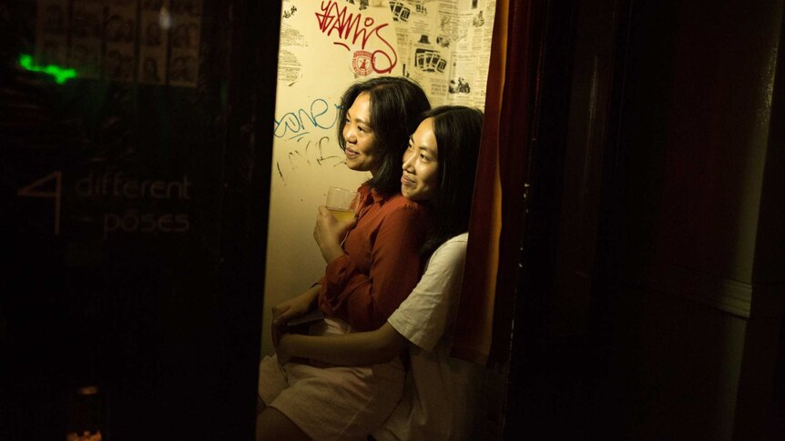 two women hugging and smiling in a photo booth