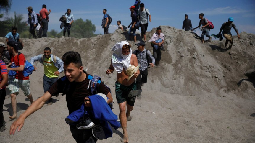 people run over a sand dune during the day