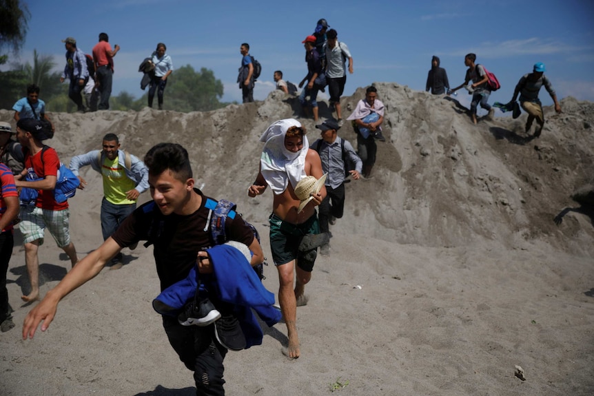 people run over a sand dune during the day