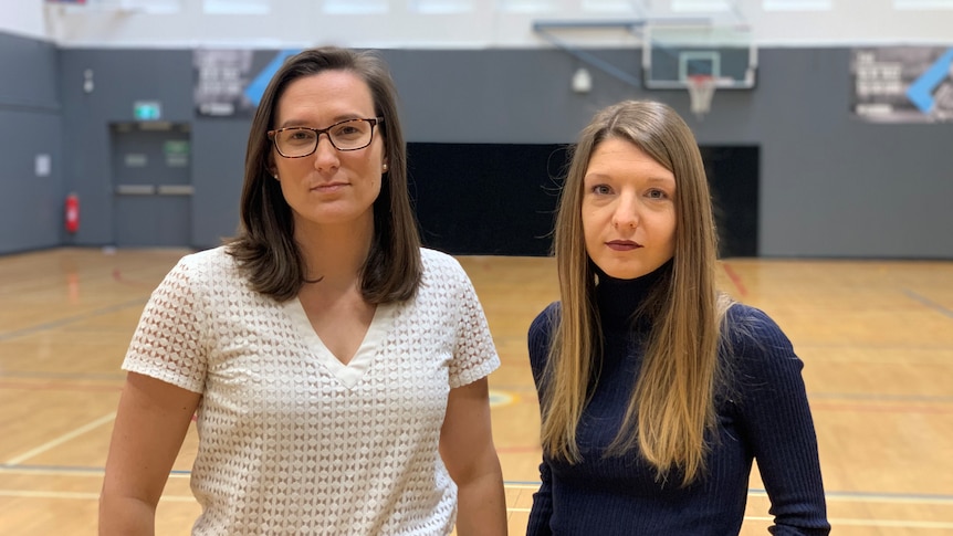 Dr Mary Woessner and Dr Aurelie Pankowiak pose for a photo on one of the basketball courts at Victoria University