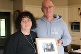 Matt and Robyn Cronin hold a framed family photo including their son Pat.