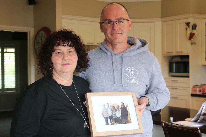 Matt and Robyn Cronin hold a framed family photo including their son Pat.