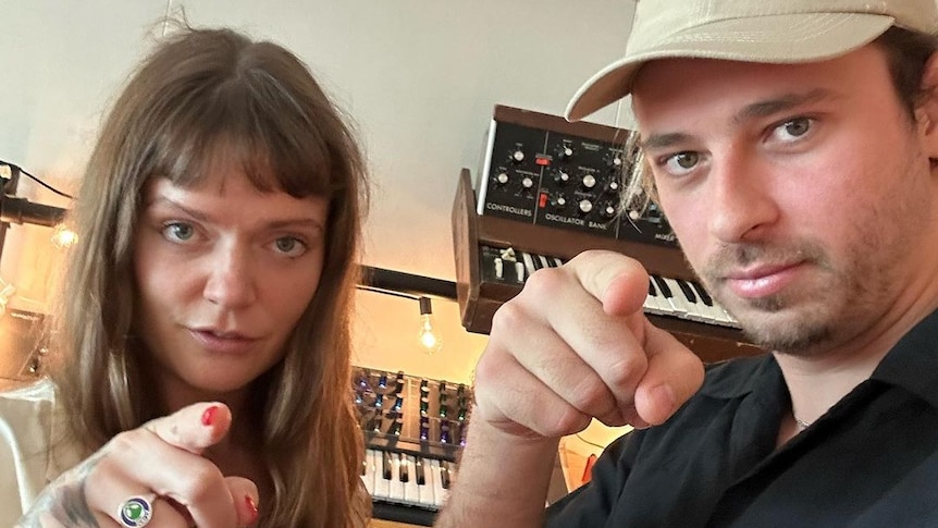Selfie of Flume and Tove Lo pointing at the camera and looking serious.