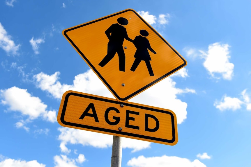 An aged signpost showing figures holding hands with words 'aged' underneath