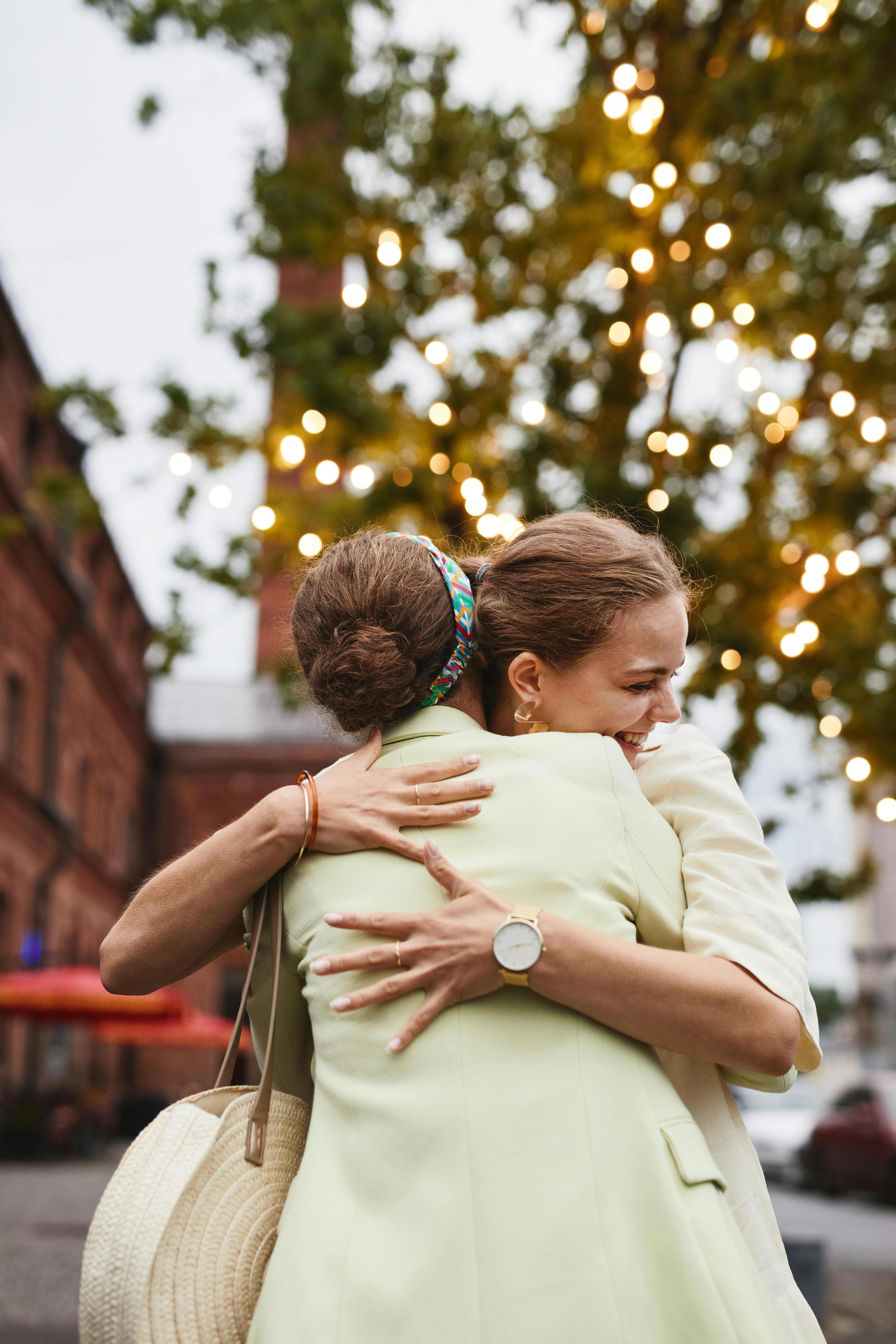 two women hugging each other in the street