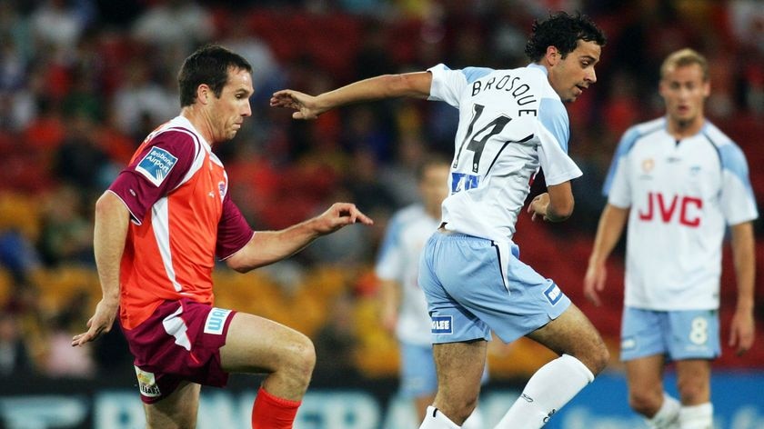 Sydney FC striker Alex Brosque gets away from Roar defender Josh McCloughin