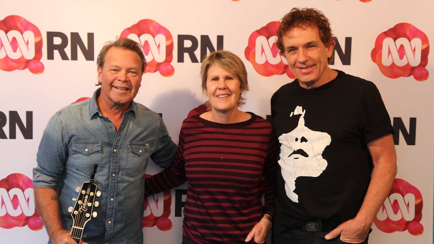Two men and a woman smile in front of an RN backdrop.