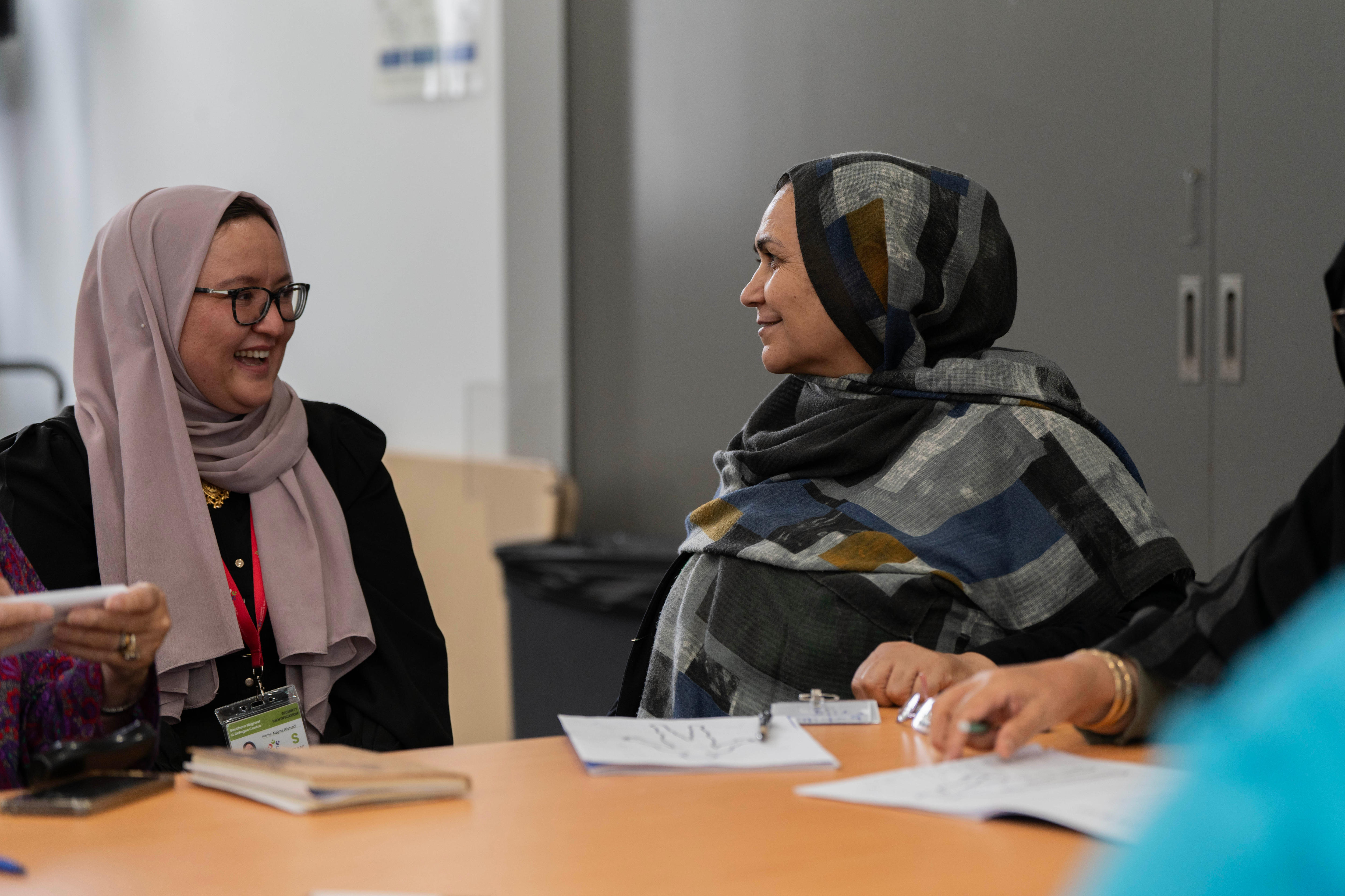 Najma y Nosrat sonríen durante la clase de inglés en el Centro de Recursos para Migrantes del Sur.