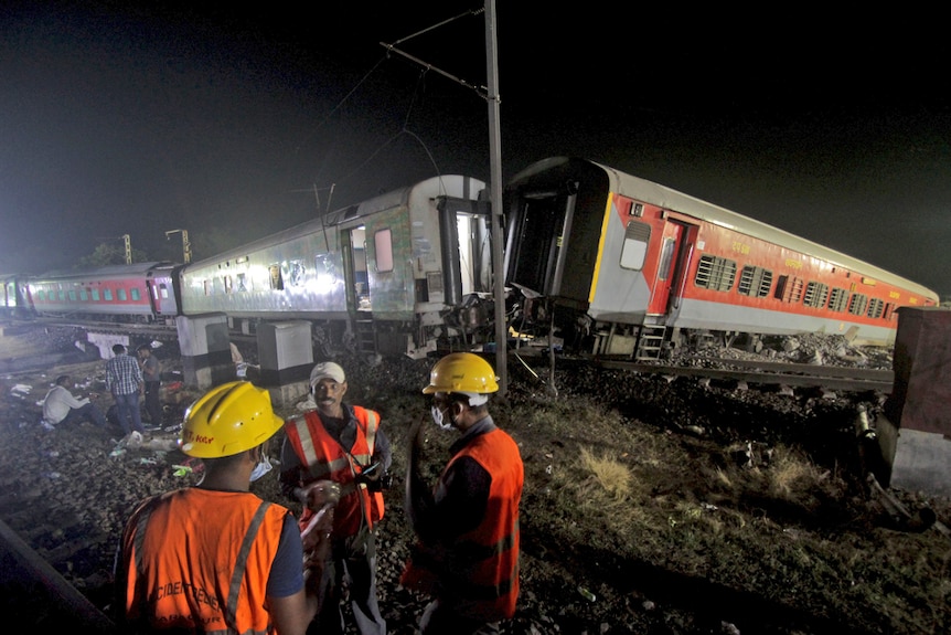 Several rescuers are seen working at the site of passenger trains accident,